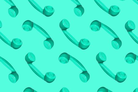 Pattern made from neo mint colored handset of a telephone on green mint background. Modern retro...