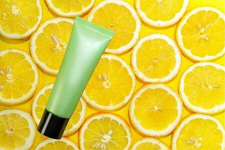Natural vitamin c serum, skincare, essential oil product. Cosmetic with fresh juicy lemon fruit slice on lime background. Beauty product mock-up. Top view, flat layの写真素材