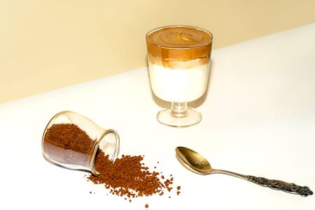 Cup of iced dalgona coffee, fashionable fluffy creamy whipped coffee on a trendy coloured background.の写真素材