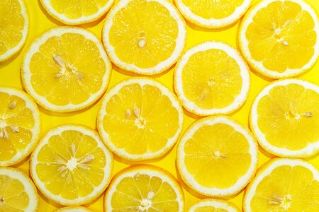 Lemon cut in half background. A slices of fresh yellow lemon pattern. Lemon pieces in different...