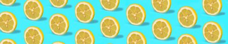 Pattern with lemon fruits. Tropical abstract lemon citrus wheel on green mint color background. Trendy summer pattern. Minimal fashion concept. Flat lay, close up.の写真素材