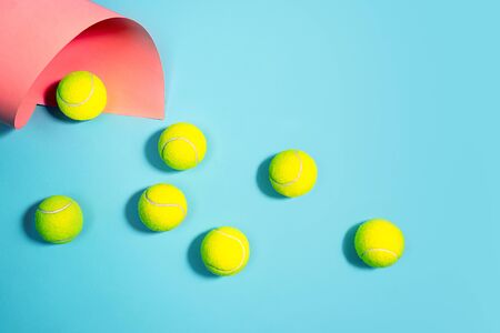 Sport concept with tennis balls close up on blue tennis court. Copy space, selective focus. Blue, pink and yellow.の写真素材