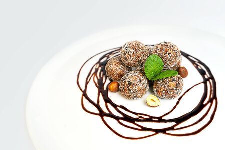 Energy balls or energy bites with oat, chocolate and coconut on pastel pink background. Healthy vegan and raw food diet. Proper nutrition concept. Selective focus. Copy space.の写真素材