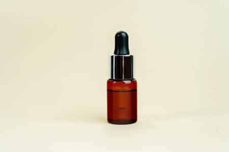 Glass bottles with herbal CBD oil, THC tincture on pastel beige background. Flat lay, minimal style. Cosmetics CBD oil. Essential natural oils for face and body.の写真素材