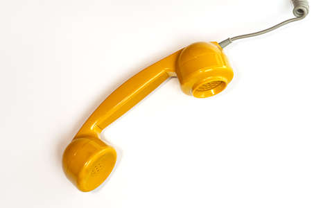 Yellow color handset of a telephone on a white background. Modern retro style. New old technology.