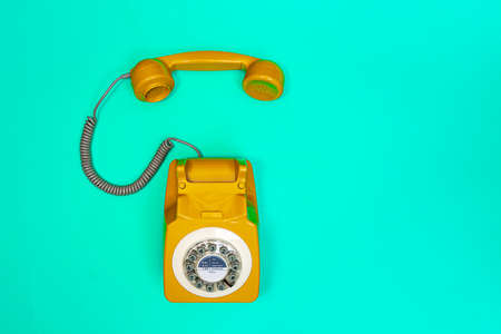 Yellow handset of a telephone on a green mint background. Modern retro style. New old technology.の写真素材