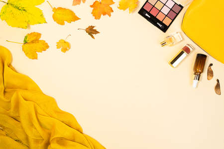 Flat lay and top view of beauty make up products and cosmetics set on autumn yellow leaves background with copyspace. Beauty concept for blogger.の写真素材