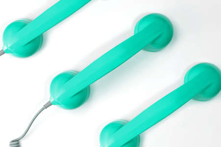 Pattern made from neo green mint color handset of a telephone on a white background. Modern retro style. New old technology.の写真素材