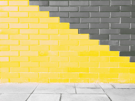 Abstract bright illuminating yellow and gray colours of wall brick as background. Trendy colors of the year 2021 - Gray and Yellow.の写真素材