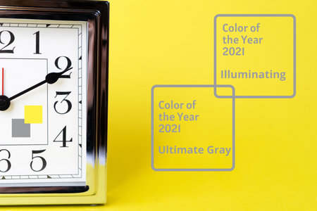 Color of the 2021 time concept with metal gold alarm clock and bright illuminating yellow and gray colours background. Shopping. Sale concept. Flat lay, top view, place for text. Abstract bright illuminating yellow and gray colours background. Trendy colors of the year 2021 - Gray and Yellow.の写真素材