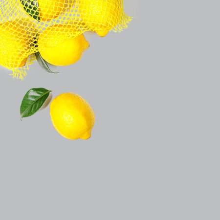 Creative layout made of bright illuminating yellow lemons on gray color background. Concept of Color of the Year 2021. Flat lay, close up.の写真素材