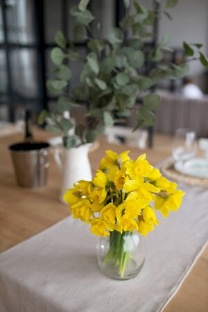 a bouquet of fresh yellow narcissuses on a tableの写真素材