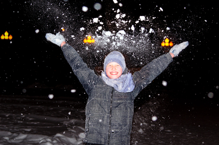 Boy throws up an armful of snowの写真素材