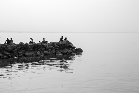 People relaxing on the lake rocksの写真素材