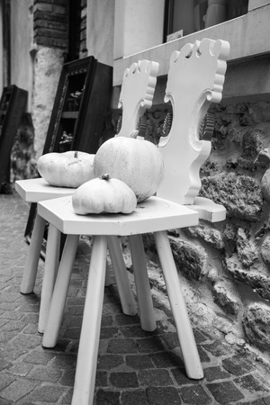 two wooden chairs painted white and two white pumpkinsのeditorial素材
