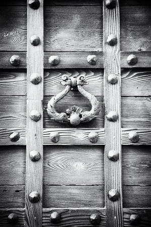 ancient door knocker of a medieval wooden portalのeditorial素材
