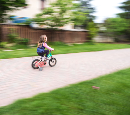 little girl ride fast on bike with castersの写真素材