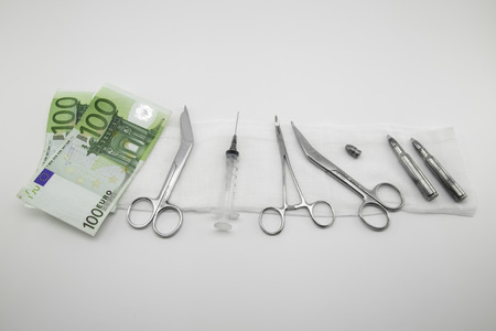 surgical instruments, syringe, ammunitions, money on white backgroundの写真素材