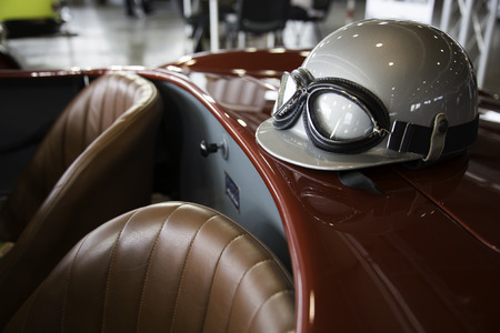 helmet and glasses resting on a luxury convertible sports carの写真素材