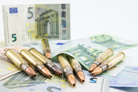 composition with golden bullets and banknotes on white backgroundの写真素材