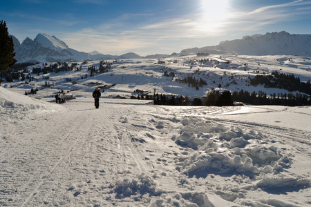 ORTISEI, ITALY - CIRCA DECEMBER 2012: People walks on ski slopes covered with snow on the Italian Alps.のeditorial素材