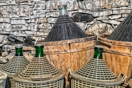 Demijohns of wine in a stone cellar.