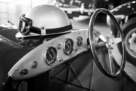 helmet and glasses resting on a old vintage sports carの写真素材
