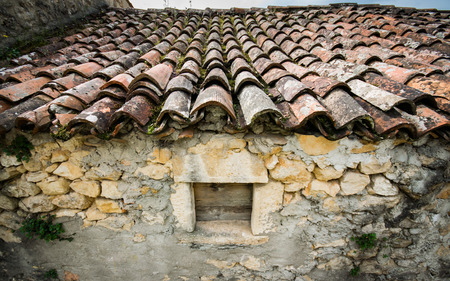 Old red roof tiles on a roof of an old cottage.の写真素材