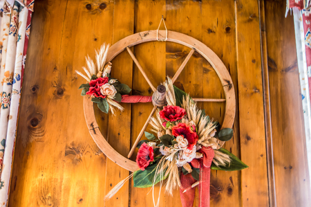 Wooden wheel of an old wagon used as a decorative object in a mountain chalet.の写真素材