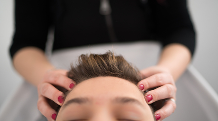 Relaxing head massage to a young boy in a spa.