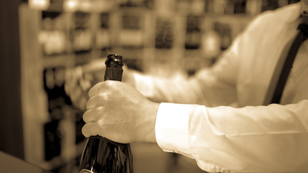 Sommelier uncorks a bottle of sparkling wine in a wine shop.の写真素材