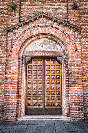 Entrance of a medieval cathedral with carved wooden door.の写真素材