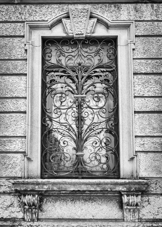 Window of an ancient Italian villa with artistic iron grill handmade.の写真素材