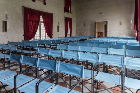Vicenza, Italy - May 13, 2015: Conference hall with canvas blue chairs and red curtains, inside villa Cordellina Lombardi in Vicenza.のeditorial素材