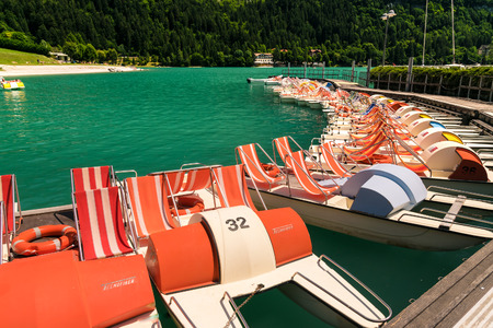 Pedal boat parked in a long line at the dock of the lake.のeditorial素材