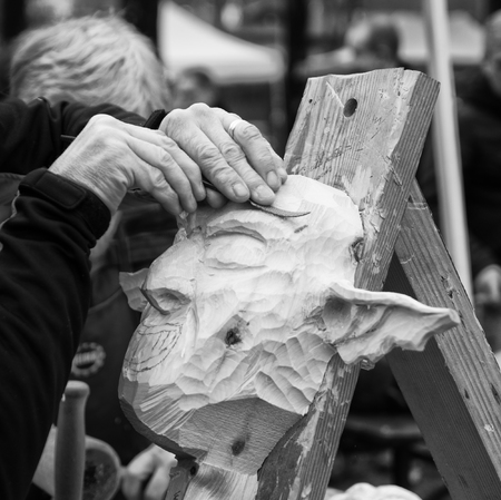 Carpenter carves a wooden carnival mask.の写真素材