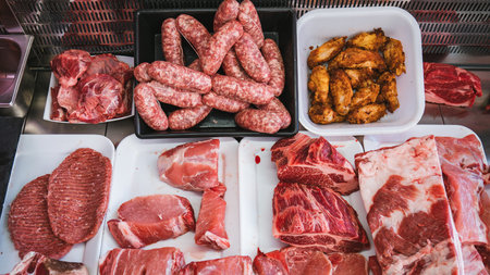 Butcher with various types of meat already filled and ready to be cooked.の写真素材