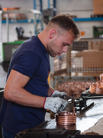 Young man working at a factory of components for the thermomechanical industry.のeditorial素材