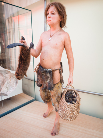 Trento, Italy - November 19, 2017: Realistic statue of a prehistoric boy in the Museum of Science in Trento.のeditorial素材