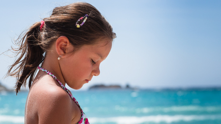 Pensive little girl on the shore of the sea.の写真素材
