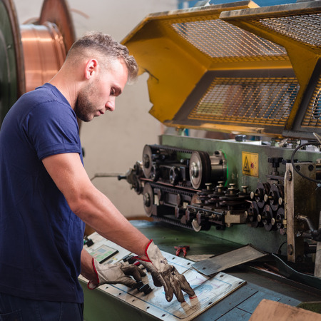 Worker in charge of programming the pipe cutting machine in a metalworking company.の写真素材