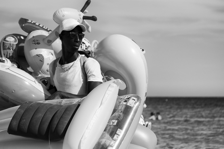 Sardinia, Italy - August 18, 2016: Street vendor of water inflatable toys in Italian beaches.のeditorial素材