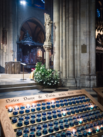 Votive candles inside the Notre Dame cathedral in Paris, France.のeditorial素材