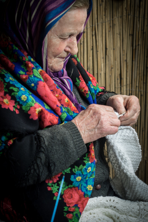 Verona, Italy - December 26, 2018: Detail of an old lady knitting a wool blanket.のeditorial素材