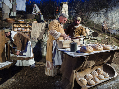 Vicenza, Italy - December 30, 2017: Baker make bread during a historical re-enactment in the caves of Villaga, Italy.のeditorial素材