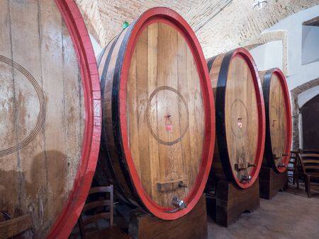 Oak barrels in an old Italian underground wine cellar.