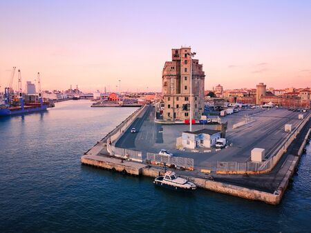 View of a quay of the port of Livorno at sunset. Abandoned building. Industrial archeology.