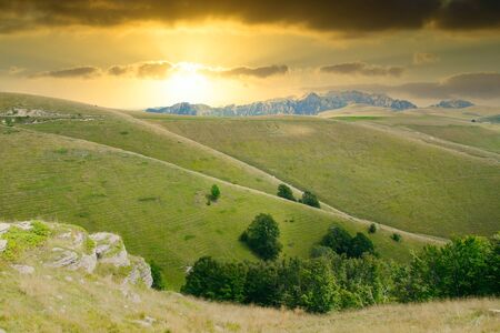 View of meadows in the mountains that create sinuous lines at sunset.の写真素材