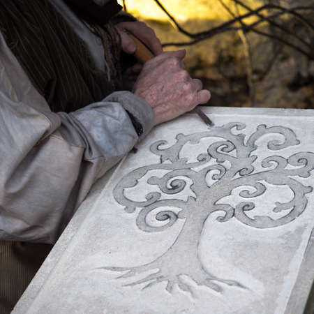 Vicenza, Italy - December 29, 2019: Stonemason carves and shapes the stone with a wooden hammer and chisel.のeditorial素材