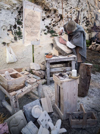 Vicenza, Italy - December 29, 2019: Stonemason carves and shapes the stone with a wooden hammer and chisel.のeditorial素材